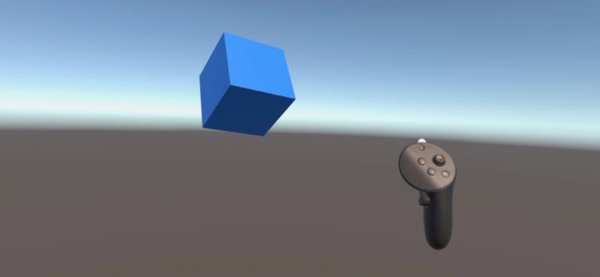 I saw the scene running on the Meta Quest Pro headset: a blue cube floating in mid-air above the ground plane, with the Quest controller visible in the lower right.